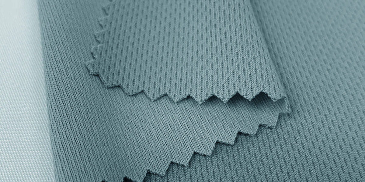 Close-up of grey-blue REPREVE recycled fabric with a pinked edge and knit texture