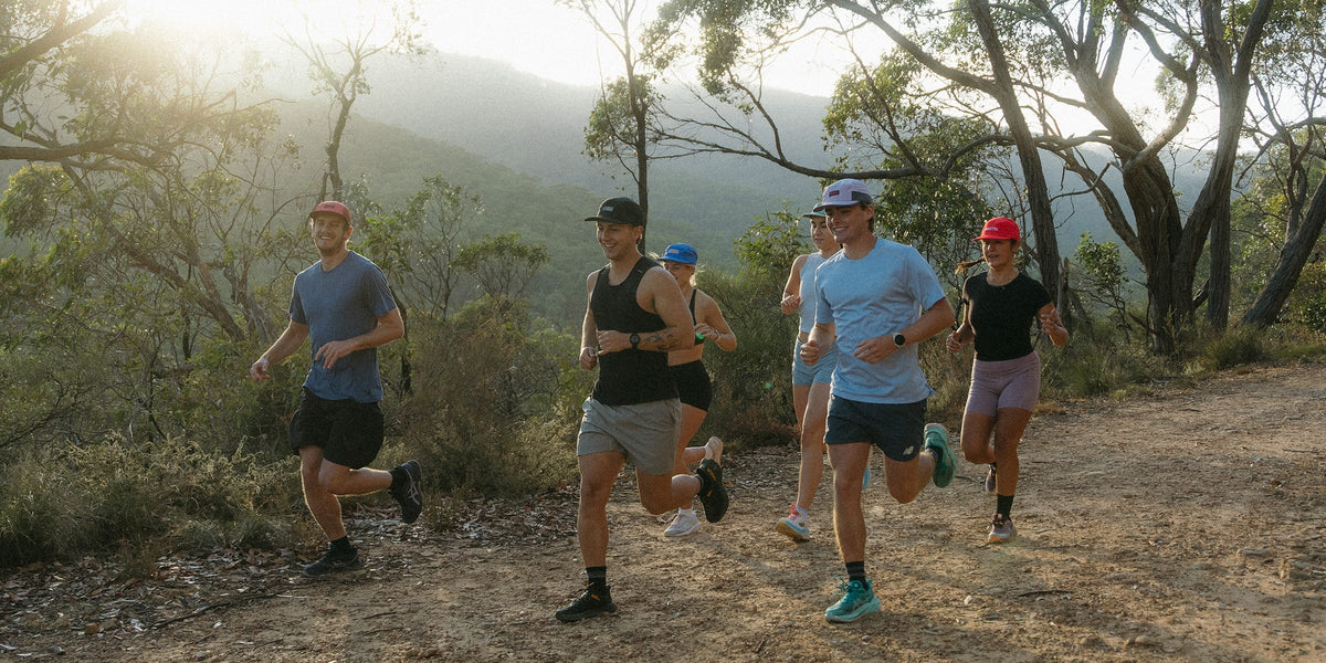 Group of runners in Fractel caps, tees and singlets on a gum tree trail from the Australian plant running collection
