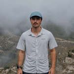 Runner wearing the light blue Fractel CP-RIDGELINE running cap on a misty mountain trail