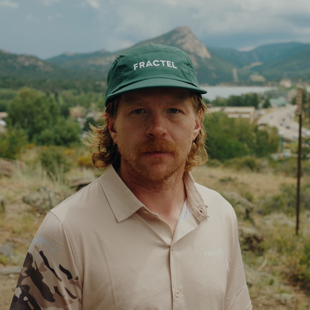 Runner wearing the green Fractel M-ARIZONA running cap in the mountains