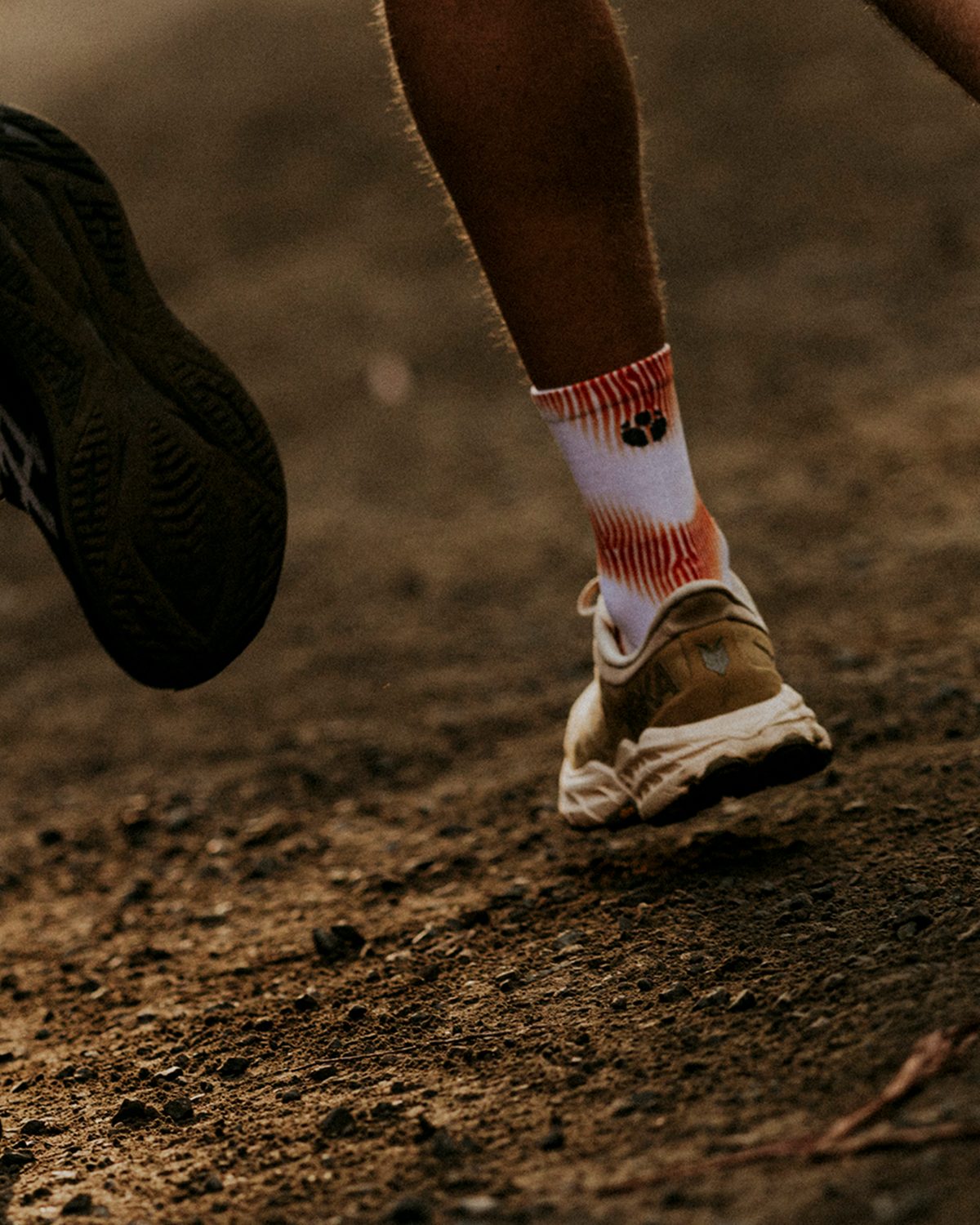 Fractel running socks worn by trail runners on a dirt track