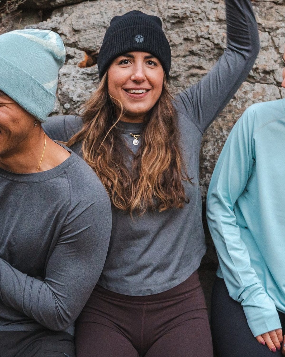 Runners in mint and black Fractel running beanies laughing together outdoors