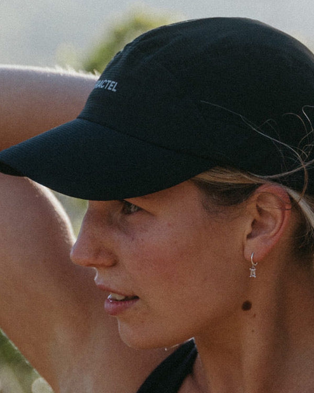 Black Fractel high ponytail running cap worn with a braid down the back