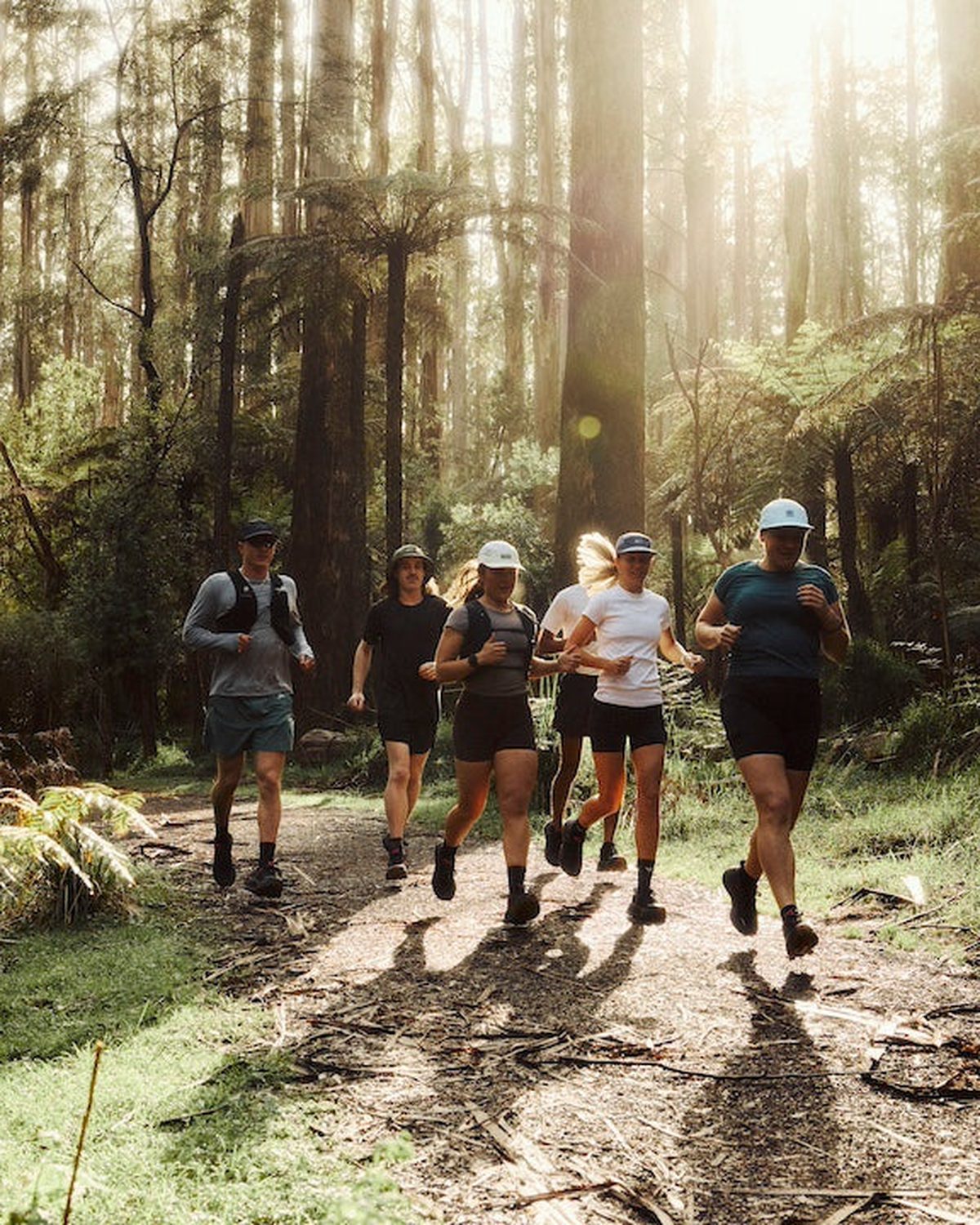 Running hats for hot weather worn by trail runners on a sunlit forest path