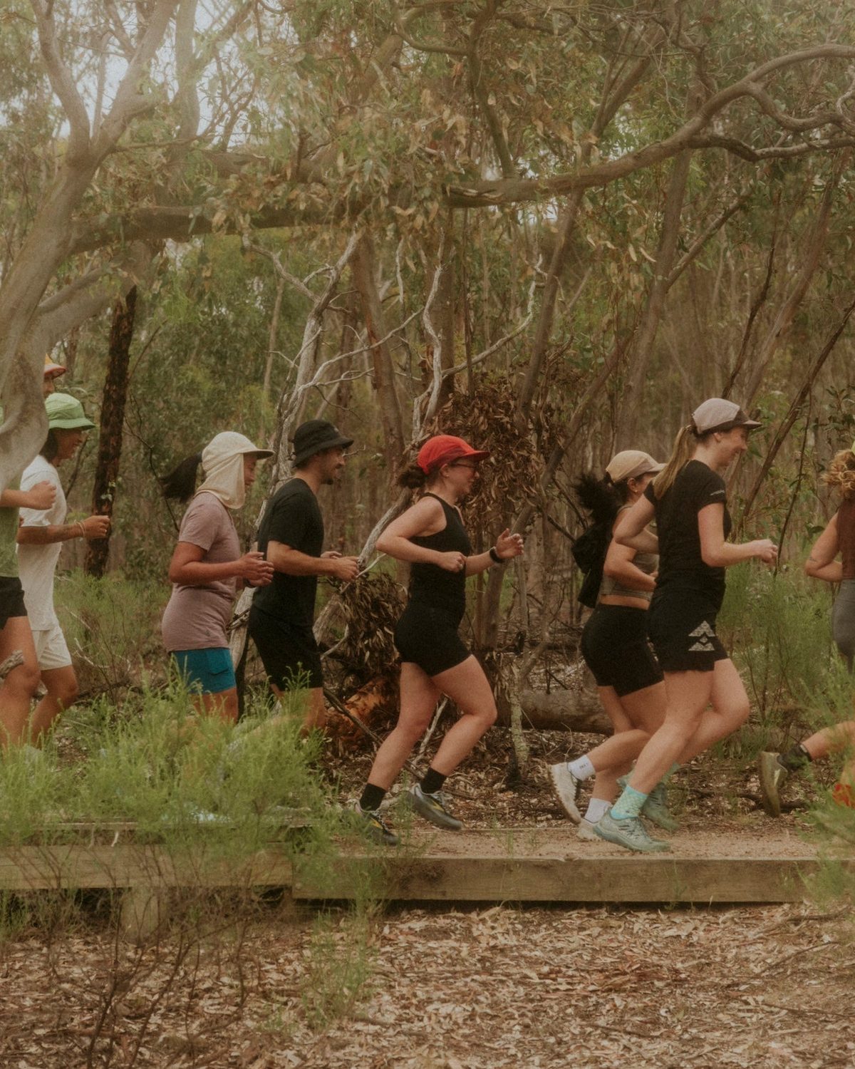 Runners in Fractel hats on a bush trail, the bird print running cap collection